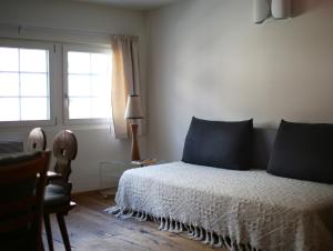 安德马特安德马特瑞士木屋酒店的一间卧室配有一张带蓝色枕头的床和一扇窗户。
