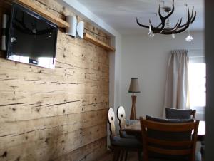 安德马特安德马特瑞士木屋酒店的客厅设有木墙,配有电视