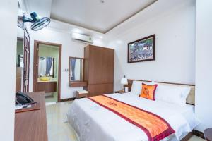 河江Đinh Gia Hotel的一间卧室配有一张床和一部电话