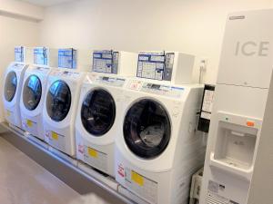 成田成田2 R51中心经济型酒店的商店架上的一排洗衣机和烘干机