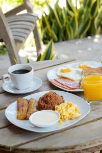 利比里亚Hotel Villa Hermosa的餐桌,包括两盘早餐食品和一杯咖啡