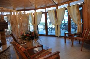 契拉勒阿卡迪亚酒店的客厅配有窗帘和鲜花桌