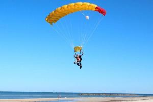 LargsLovely Modern 3br 2bth Beachside suburb Home的海滩上降落伞的人