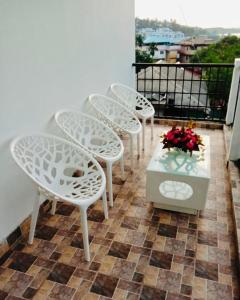 布莱尔港Zcube Andaman的阳台上的一组白色椅子和一张桌子