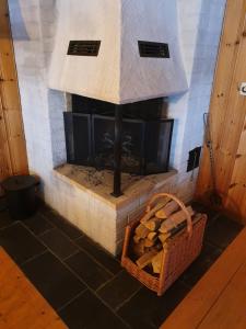 HargSjöstuga Vätö的石头壁炉,配有一篮柴火