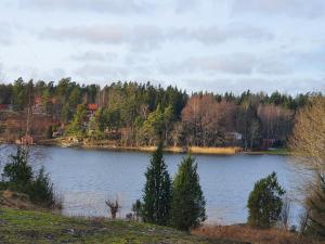 HargSjöstuga Vätö的一边有树木的大湖