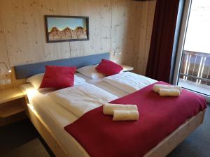 拉姆绍达赫斯坦Berghotel Türlwand的一间卧室配有一张带红色枕头的大床
