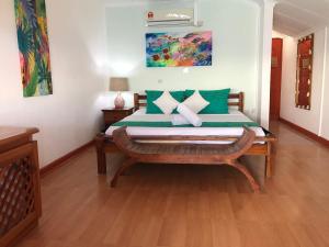 拉迪格岛L'海洋酒店的一间卧室配有带绿色和白色枕头的床