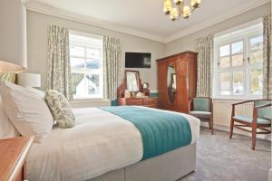科尼斯顿The Yewdale Inn and Hotel Coniston Village的一间卧室配有一张床、一把椅子和窗户。