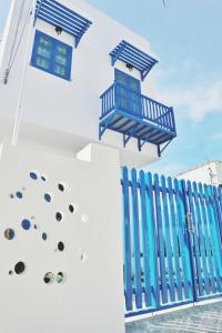 潘郎Cube homestay Phan Rang cách biển 300m to the beach的一座带蓝色栅栏和窗户的建筑