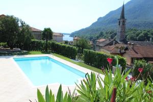 梅尔戈佐Oleandro 2 apartment in Villa Cerutti的一座带教堂的庭院内的大型游泳池