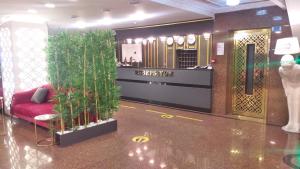 加济安泰普Yilmazel Hotel的大堂里摆放着红色的沙发,种有植物