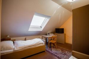 克尔斯特尔巴赫Angelis Pension的一间卧室配有一张床、一张桌子和一个窗户。