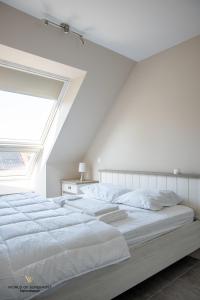 奥斯坦德Spacious apartment in the heart of Ostend near the sea的卧室配有一张白色大床和天窗
