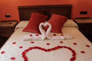 达罗卡Hotel Apartamentos Melihah的一张有两只天鹅的睡床,看起来像心脏