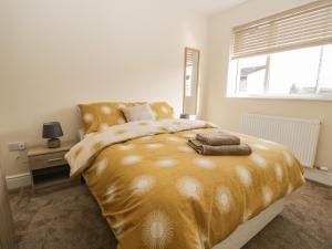 WigtonThe Croft Bungalow的一间卧室设有一张带窗户的大型金色床