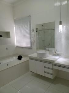 圣若昂-巴蒂斯塔-杜格罗里亚Pousada São Francisco的白色的浴室设有浴缸、水槽和浴缸。
