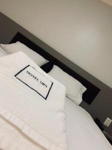 索里苏Hotel Uipi的一间酒店客房,配有枕头,上面有酒店标志