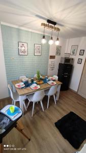 凯斯特海伊Zala Holiday Apartman的餐桌、白色椅子和厨房