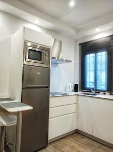 塞特尼尔Casa cueva La Tosca的厨房配有不锈钢冰箱和白色橱柜