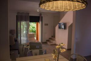 托罗埃利亚-德蒙特格里Villas y apartamentos Costa Brava的客厅配有桌椅和吊灯。