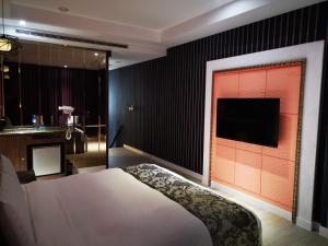 台北情觅精品汽车旅馆的一间卧室配有一张床,墙上配有电视
