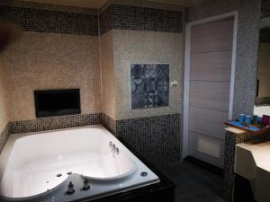 台北情觅精品汽车旅馆的带浴缸的浴室、电视和
