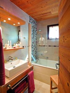 普拉洛尼昂拉瓦努瓦斯Chalet Hôtel Les Airelles的浴室配有水槽、淋浴和浴缸。