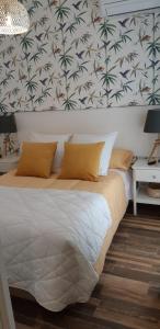 康塞普西翁新镇Apartamentos A Poniente的一间卧室设有一张大床,墙上有棕榈树
