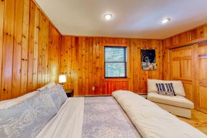 HarrisonOlde Loon Landing的卧室设有木墙、一张床和椅子