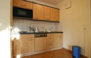 奥斯赛拜-屈隆斯博恩Haus-Ostseewelle-Wohnung-5-411的一间带木制橱柜和微波炉的厨房