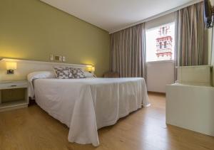 埃希哈Hotel Platería的卧室配有白色的床和窗户。