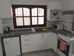 萨尔塔Departamento PB的厨房配有白色橱柜、水槽和窗户。