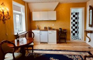 布罗艾厄Old Roses Guesthouse的一间厨房,内设白色橱柜和一张桌子