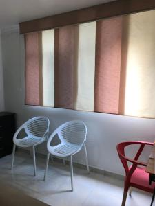 麦德林Apartamentos Amoblados JG de la 70的两把白色椅子坐在带窗户的房间