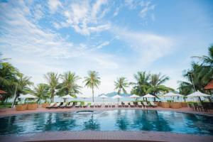 下龙湾Tuan Chau Resort Ha Long的度假酒店的游泳池配有椅子和遮阳伞
