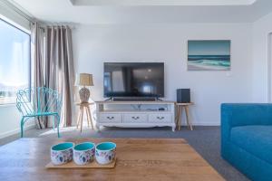 特卡波湖Neptune - Lake Tekapo的客厅配有电视和蓝色沙发。