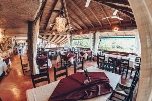 Los Guineos Perdidos阿尔托斯卡诺弘多酒店的用餐室设有桌椅和窗户。
