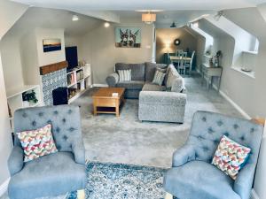 滨海韦斯顿Hill Cottage的客厅配有2把蓝色椅子和桌子