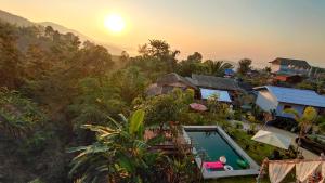 清莱บ้านภูคำฟ้า ดอยปู่ไข่ Baan Phu Kham Fah的享有带游泳池的度假村的空中景致