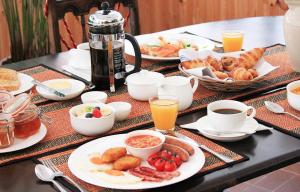 森嫩湾塞恩赖斯旅馆的早餐桌,包括早餐食品、咖啡和橙汁