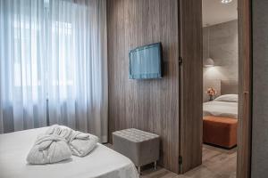 里米尼安必特全景酒店的一间酒店客房,配有一张床和一台墙上的电视