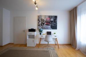 汉诺威- Sweet Dreams - Gästeunterkunft Hannover的客厅配有书桌和墙上的照片