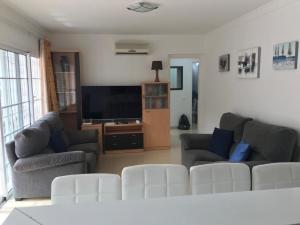 波多黎各Bungalow Isla Margarita的客厅配有2张沙发和1台平面电视