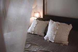 法萨诺Masseriola Antiche Fogge的一间卧室配有带白色枕头和灯的床