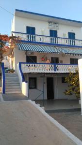 利普西岛Hotel Glaros Lipsi的带阳台的建筑,前面设有楼梯