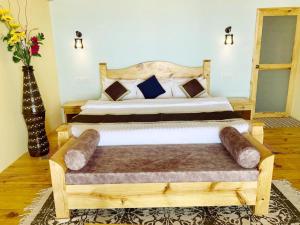 阿贡达Agonda Serenity Beach Villa的一间卧室配有一张带长凳的大型木床