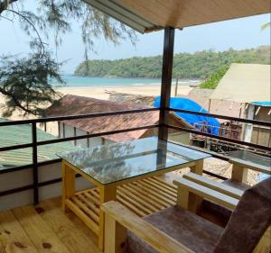 阿贡达Agonda Serenity Beach Villa的海滩景阳台的玻璃桌