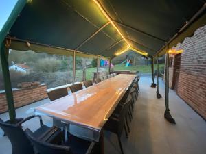 巴尔沃Villa Agni的帐篷下一张长木桌子和椅子