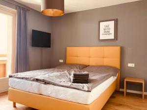 滨湖采尔Alpensoul Apartments的一间卧室配有一张黄色床头板的床